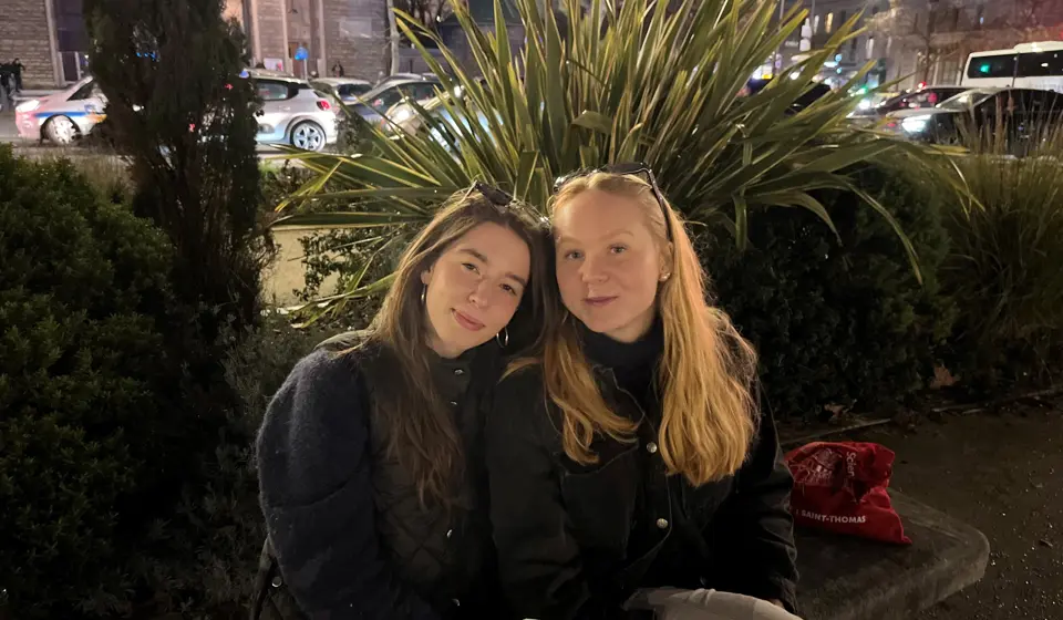 Två studenter som sitter på en parkbänk i Paris.