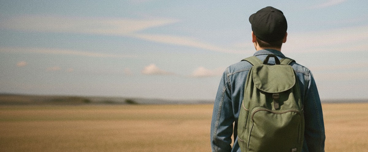 Manlig student syns bakifrån med blicken mot horisonten.h