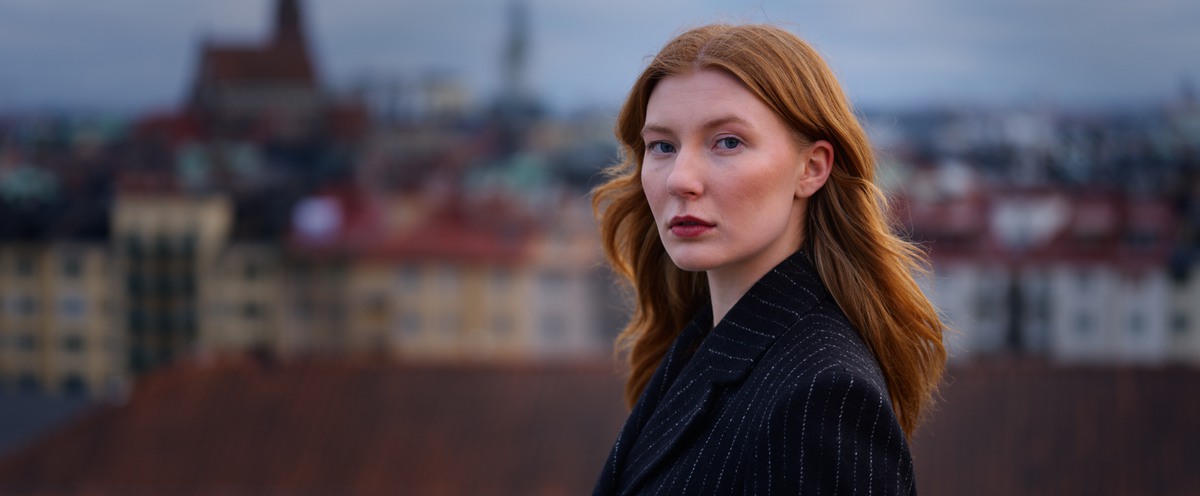 Reklambild med student på Försvarshögskolans tak som tittar in i kameran.