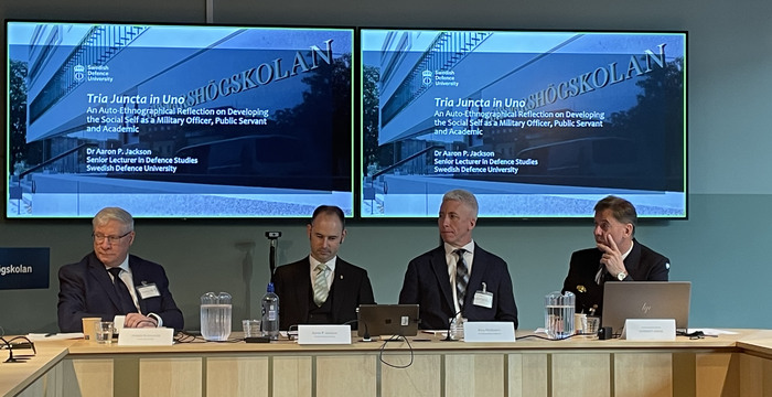 Paneldeltagare som sitter på rad. 