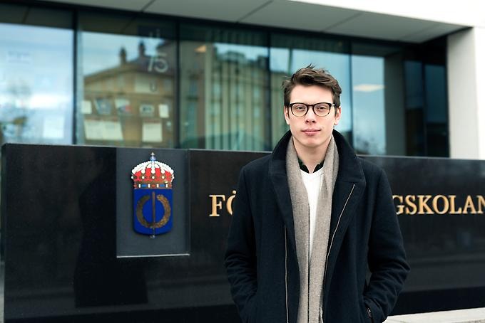 Porträtt av studenten Magnus Lundström framför Försvarshögskolans entré.