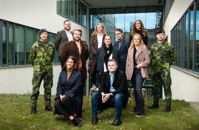 Gruppbild av kårstyrelsen 2020-2021 med Försvarshögskolans huvudbyggnad i bakgrunden.