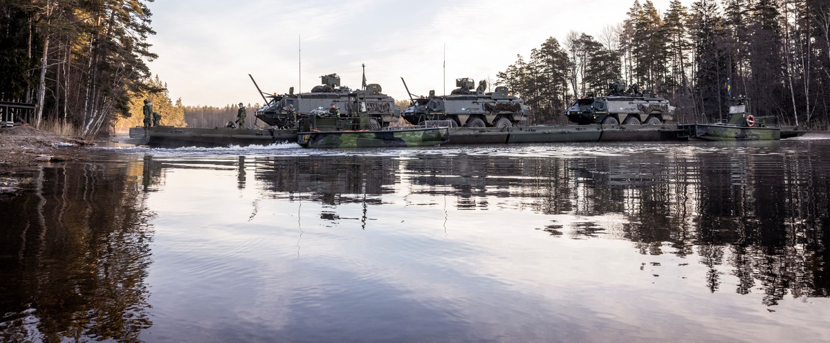 Tanks crossing a river in a forest. 