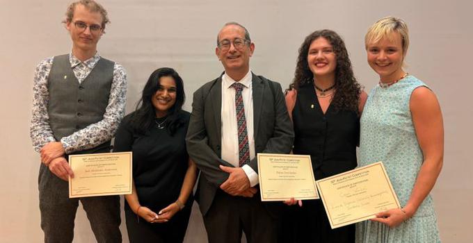 Tävlingsdeltagarna poserar med sina diplom och sin handledare samt en av tävlingsarrangörerna.