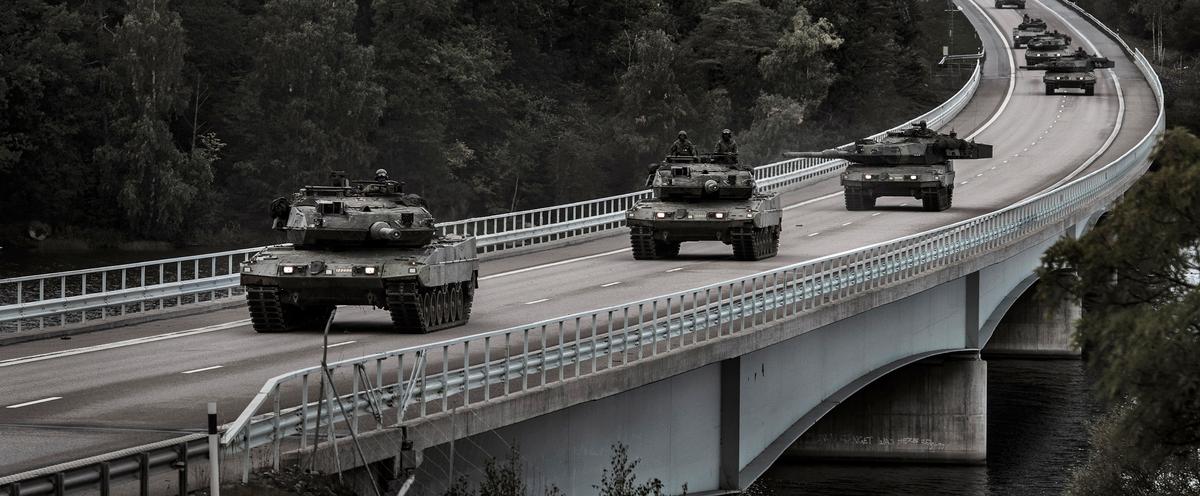 Militära fordon på en bro.