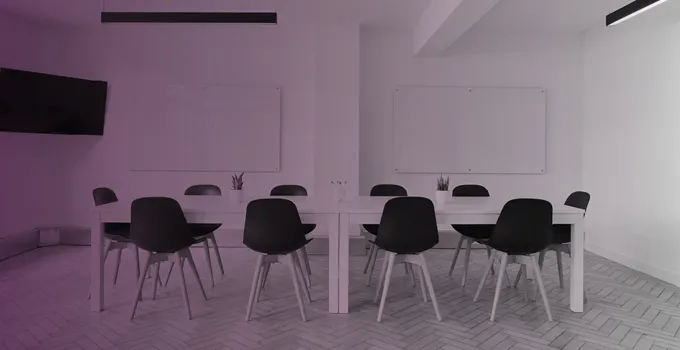 Rosatonad bild på bord och stolar i ett konferensrum.