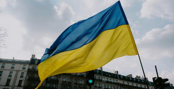 Ukrainas flagga mot molnig himmel. 