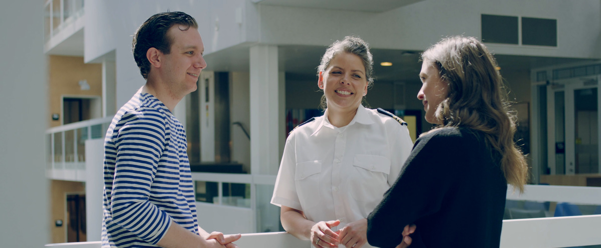 Civila och militär student pratar i ljusgården.