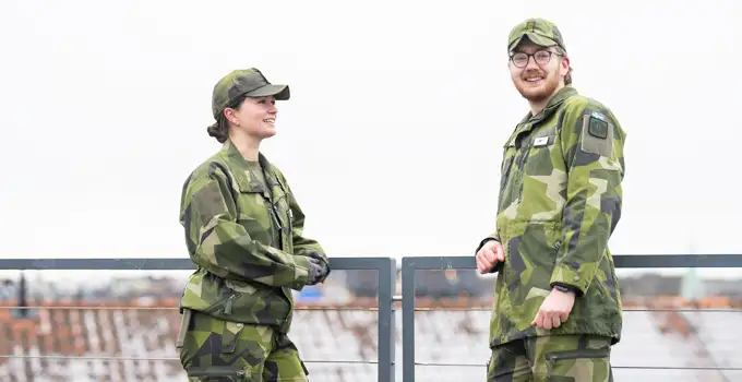 Två kadetter stående på Försvarshögskolans tak.