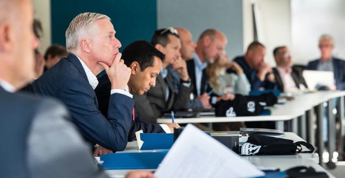 Deltagare i en workshop sittandes vid ett bord. 