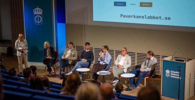 Paneldeltagare på scenen i Sverigesalen vid en konferens. 