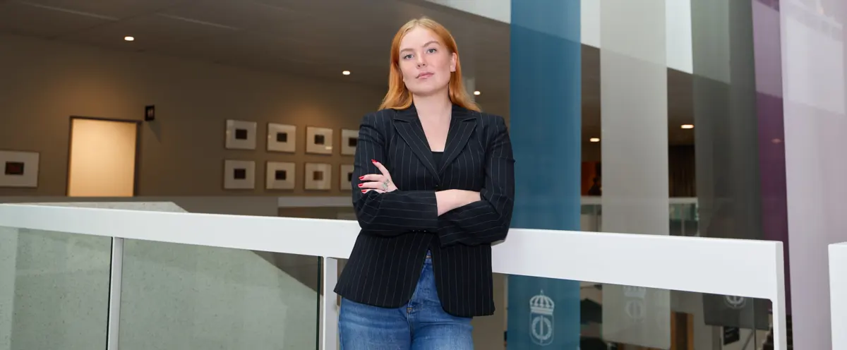 A woman leaning on a railing in a building.