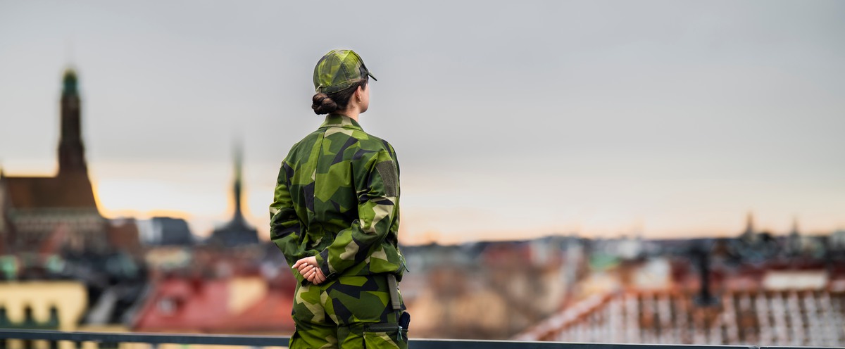 Kvinnlig kadett spannar ut över takåsar.