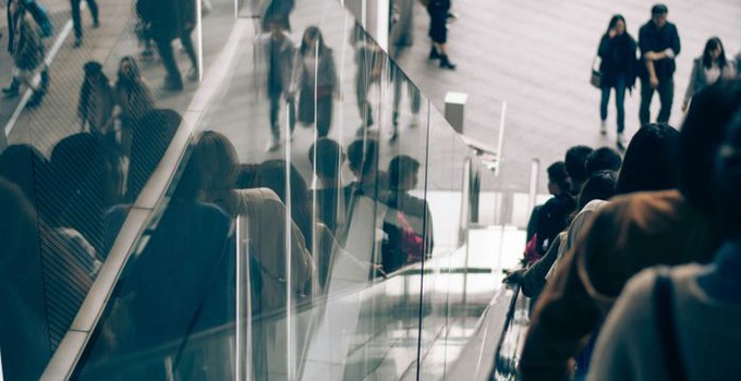 Personer bakifrån som åker rulltrappa.