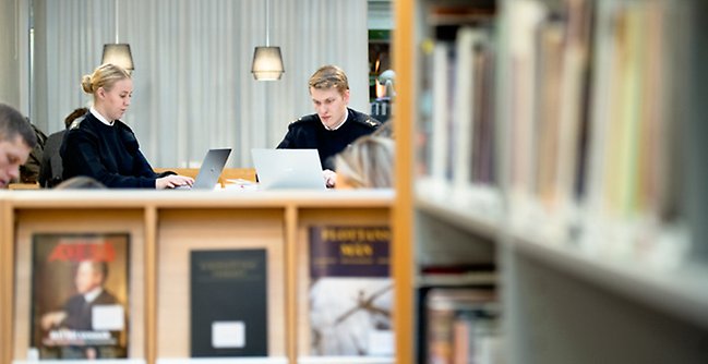 Några personer som sitter vid ett bord med bärbara datorer.