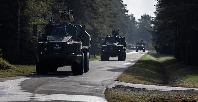 Militära fordon på en väg.
