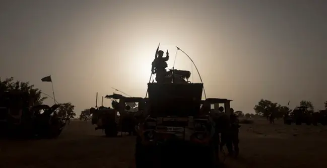 En grupp människor som står på ett militärfordon.
