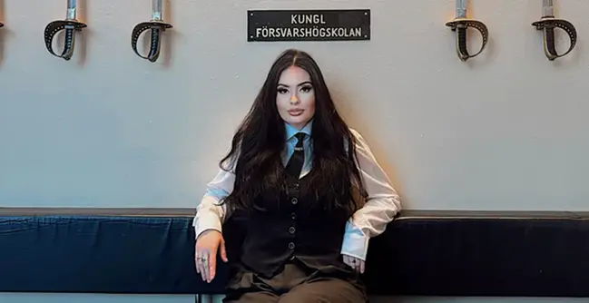 En kvinna som sitter på en bänk i ett rum.